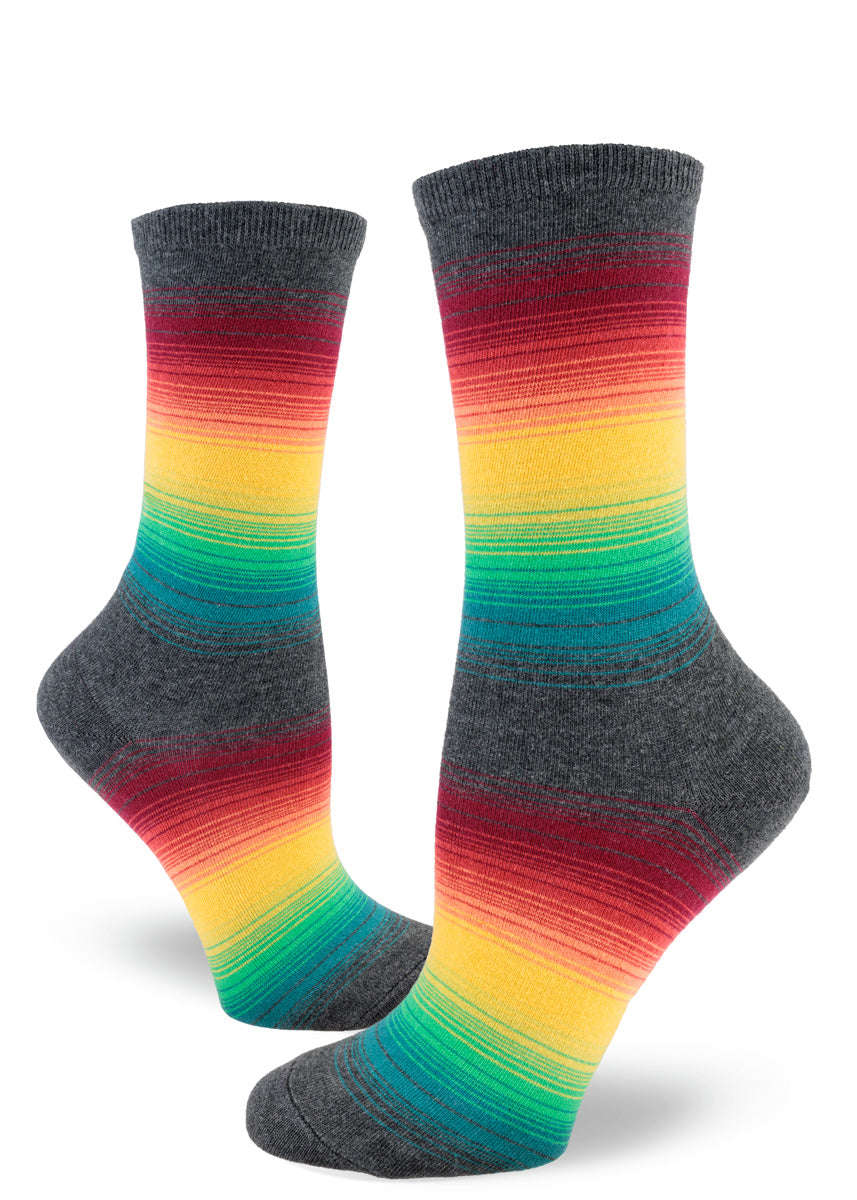 Crew socks for women with thin rainbow stripes set against a charcoal gray background.