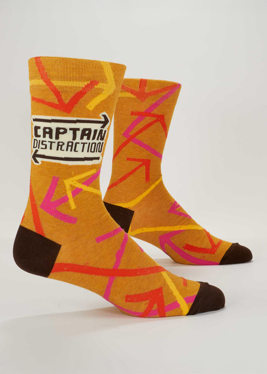 Mustard yellow crew socks for men with an allover pattern of colorful arrows pointing in different directions and the words &quot;Captain Distraction.&quot;