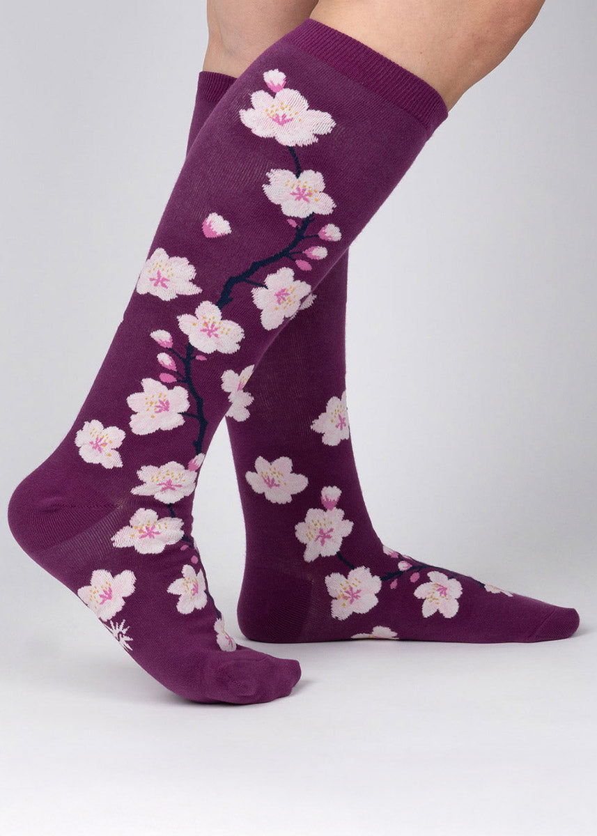 Purple wide-calf knee socks with an allover pattern of pink and white cherry blossoms. 