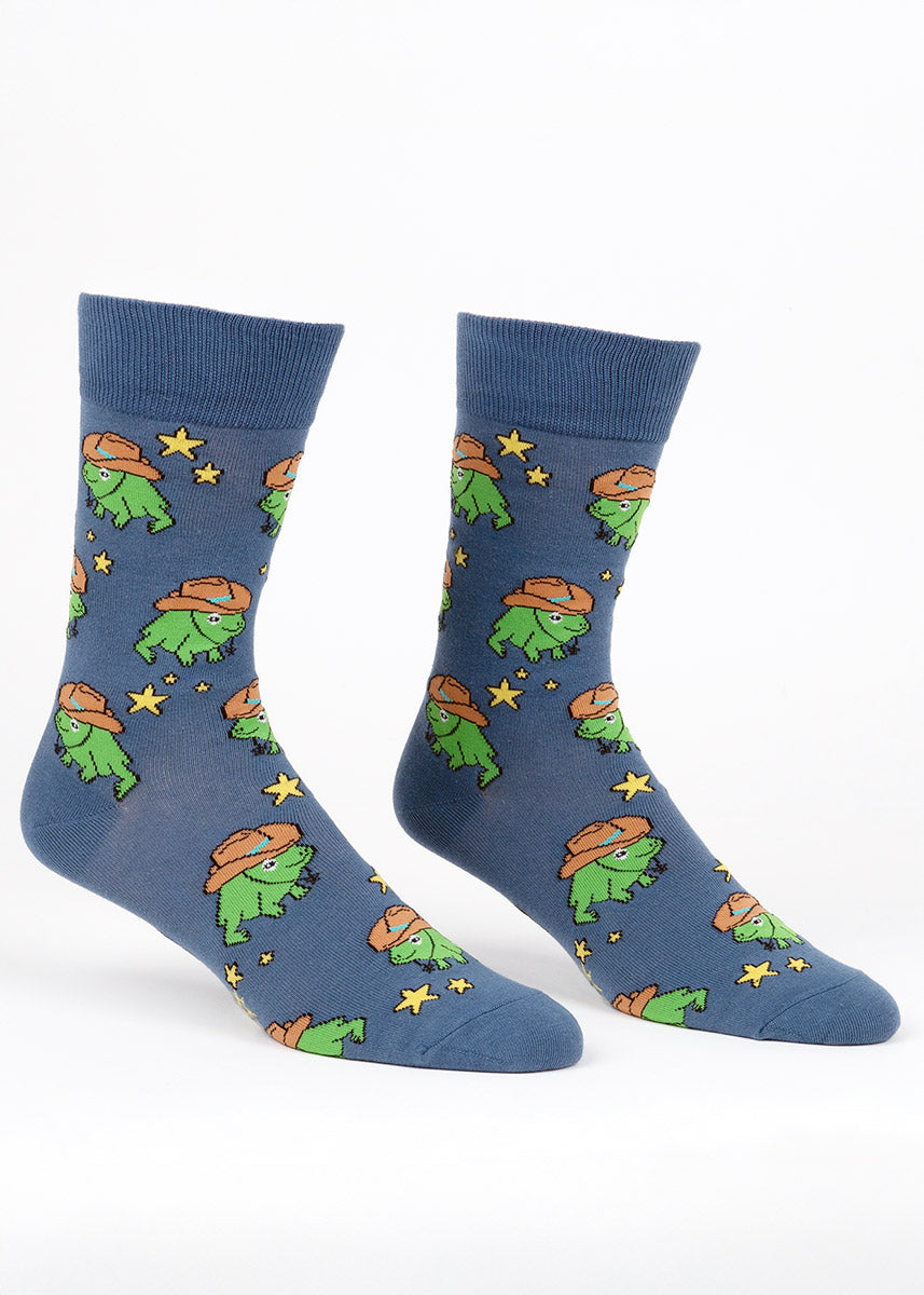 Blue crew socks for men with an allover pattern of green cartoon frogs wearing cowboy hats surrounded by yellow stars.