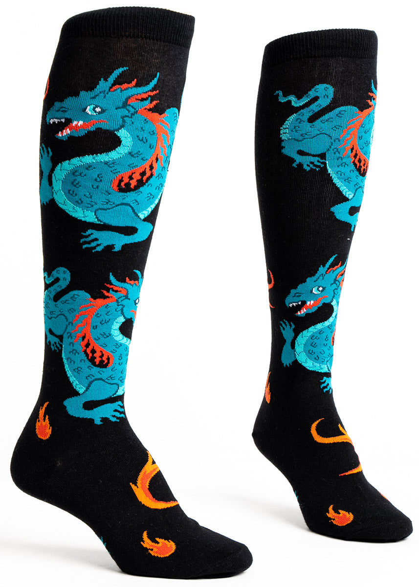 Black knee socks for women with green dragons wrapping around the leg along with bits of fire. 