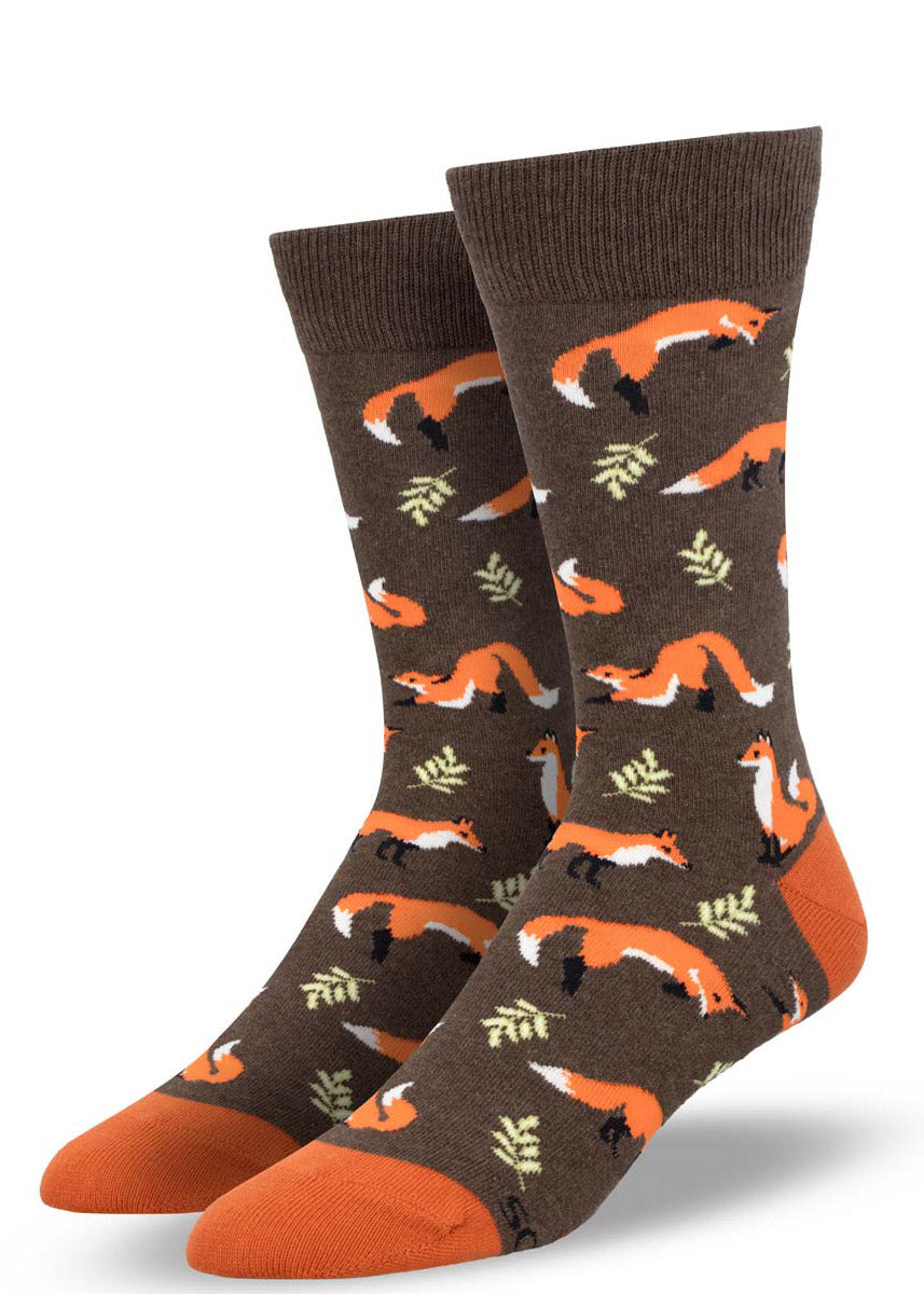 Brown crew socks for men with an allover pattern of orange foxes and forest leaves.