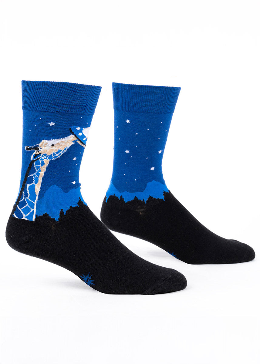 Blue and black crew socks for men that feature a giraffe reaching up into the sky and biting onto a UFO against a starry night sky.