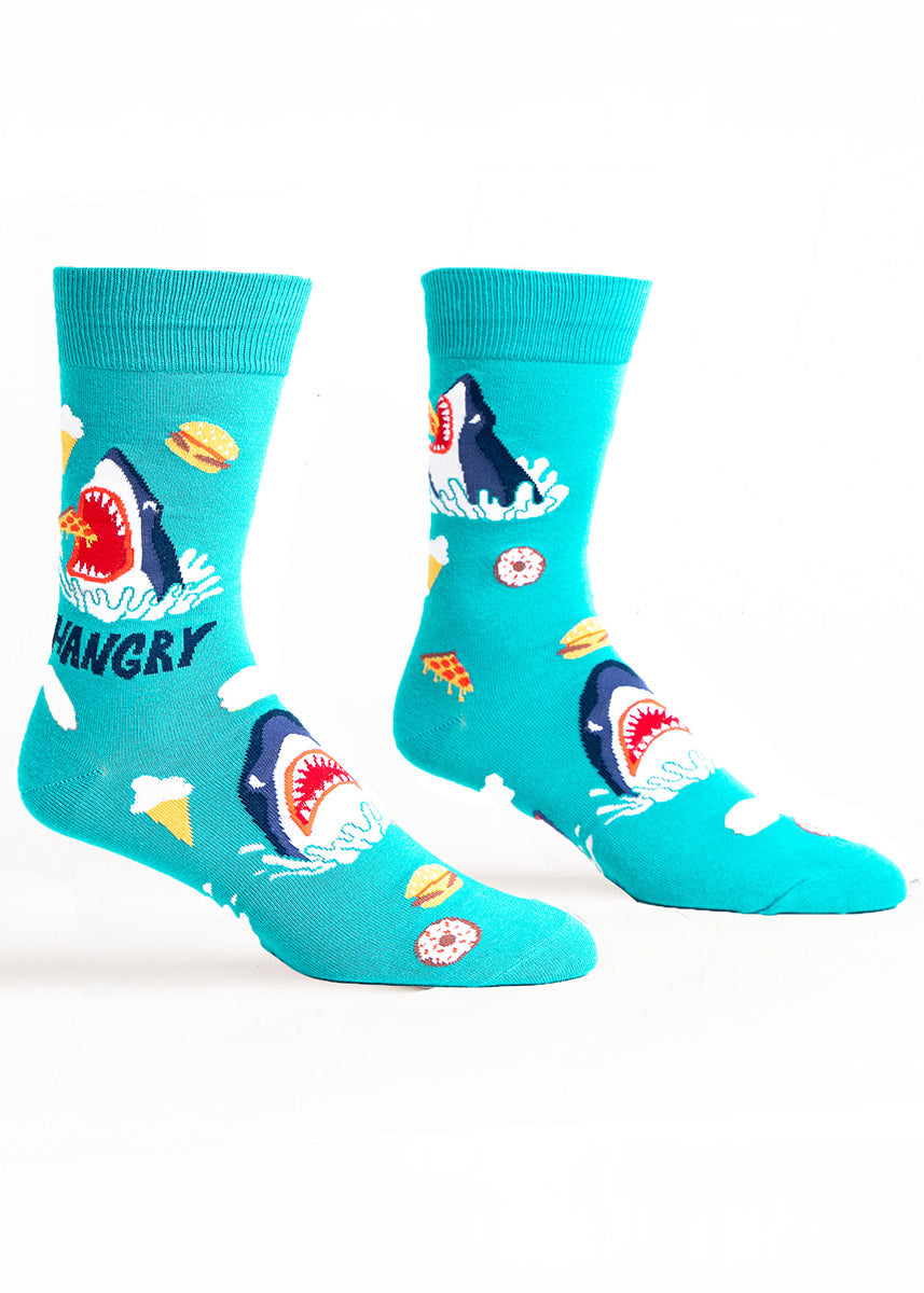 Teal crew socks for men with a pattern of junk food with sharks opening their jaws out of the water to eat them along with the word "Hangry."