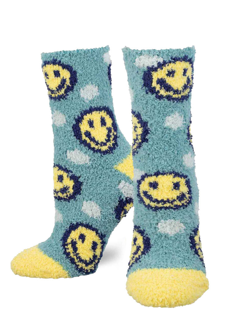 Blue fuzzy socks for women with an allover pattern of yellow smiley faces and white polka dots.