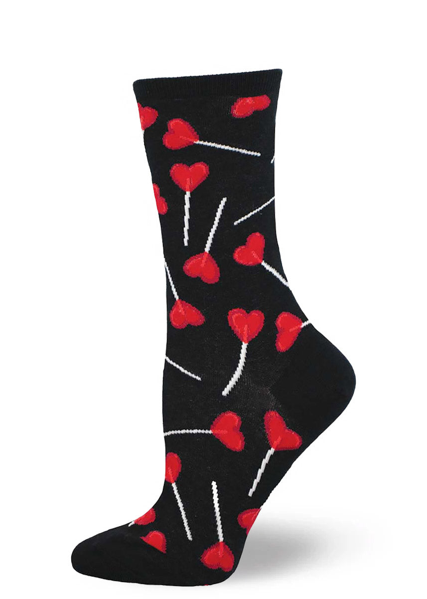 Black crew socks for women with an allover pattern of red heart-shaped lollipops.