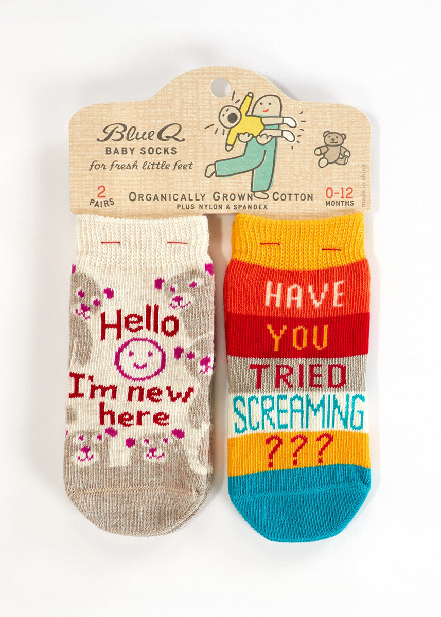 Two pairs of socks for babies: one pair features a cartoon baby surrounded by bears with the words &quot;Hello I&#39;m New Here&quot; and the other has a yellow, red, and blue striped pattern with the words &quot;Have You Tried Screaming???&quot;