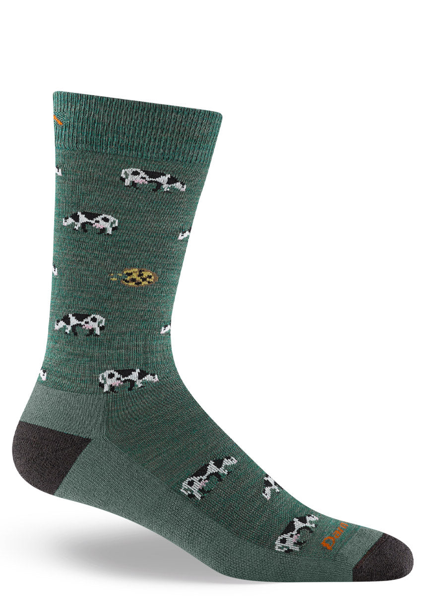 Green wool crew socks for men feature a pattern of black and white cows as well as chocolate chip cookies.