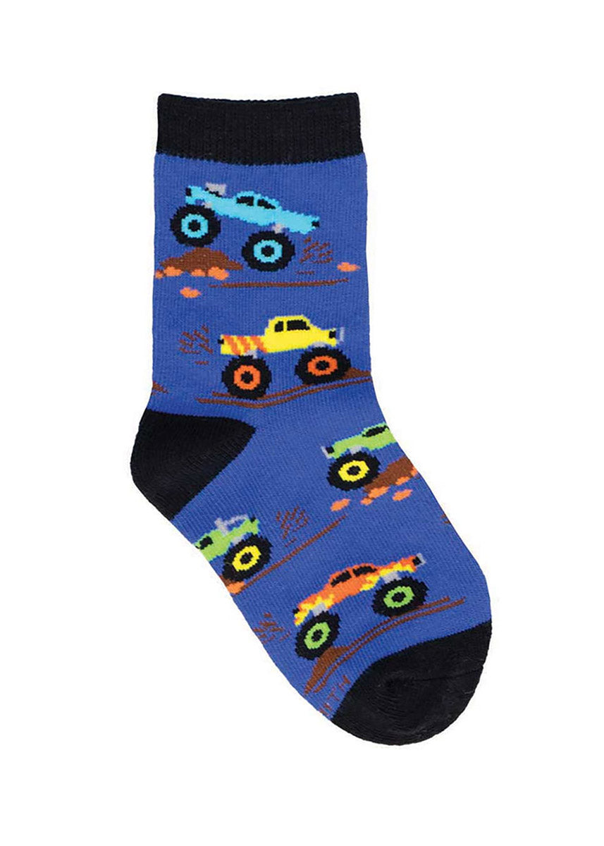 Blue crew socks for kids with an allover pattern of colorful monster trucks driving and jumping over dirt jumps.