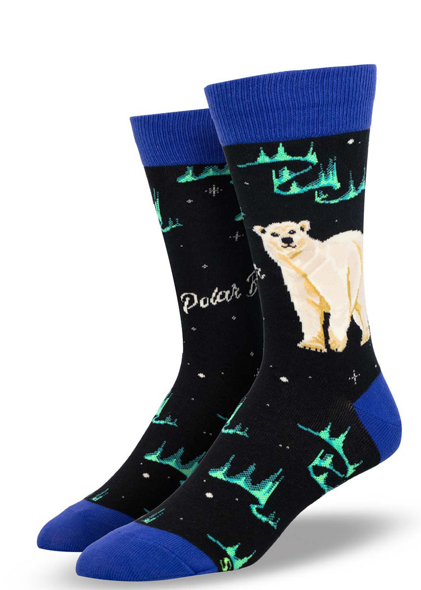 Black crew socks for men that feature a white polar bear against a backdrop of teal northern lights and stars.