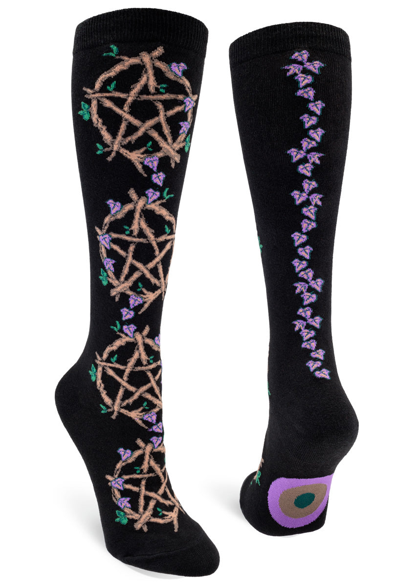 Black knee socks for women with five-pointed star symbols made from vines sprouting green and purple leaves that climb up the front, and a purple vine winding its way up your ankles on the back. 