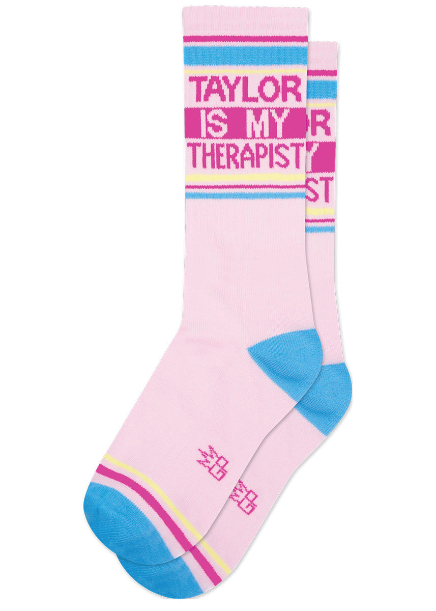 Pink retro gym socks with hot pink, blue, and yellow stripes and the phrase “TAYLOR IS MY THERAPIST.&quot;