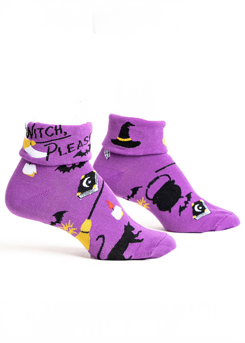 Purple turn-cuff crew socks for women with an allover pattern of witchy designs, such as a broom, bats, candles, a black cat, cauldrons, and spell books. The turn cuff design features the words &quot;Witch, Please&quot; and a moon design.