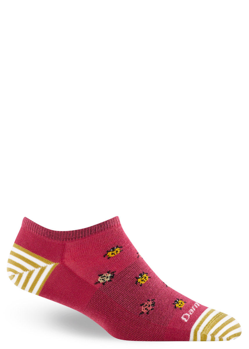 Red low-cut wool ankle socks feature a pattern of multi-colored ladybugs and white and yellow stripes at the heel and toe. 